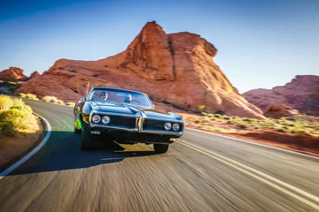 Crédence de cuisine en verre imprimé Voitures rapides Couple roulant ensemble dans une voiture vintage cool à travers le désert