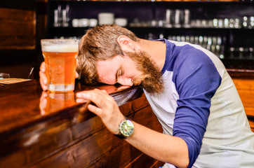 bearded drunk man sleeps with Barney table with a glass of beer