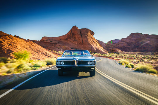 driving fast through desert in vintage hot rod car