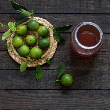 Green Kumquat fruit on wooden background