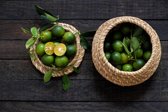 Green Kumquat fruit on wooden background