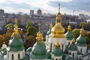 Fototapeta na wymiar Cupolas of Saint Sophia Cathedral in Kyiv, Ukraine. Soviet-built houses are on the background.