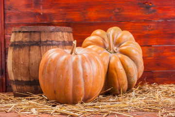 Autumn Pumpkin Thanksgiving Background . Orange pumpkins over wooden table.Pumpkins and straw in old barn