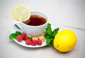 Tea with mint, brown sugar, raspberry and lemon on  table