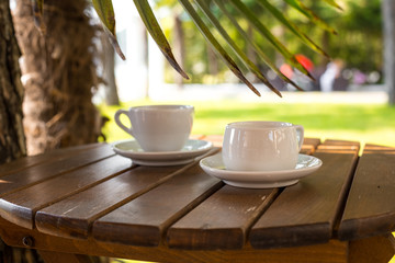 two cups of coffee  on table over sea landscape with sunlight. Beauty nature background