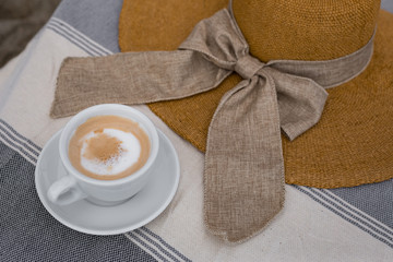 Summer coffee break , female straw hat and cup of coffee