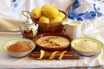 Composition with rice pudding ingredients on embroidered tablecloth
