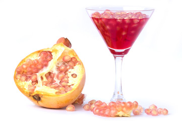 A glass of pomegranate juice with fresh pink pomegranate fruits
