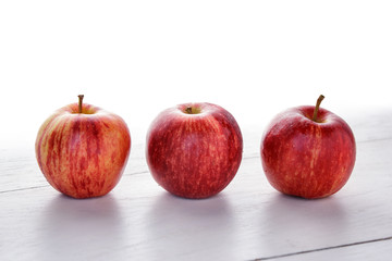 fresh red apple on white wooden table