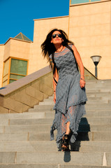 woman on a city street climbs the stairs