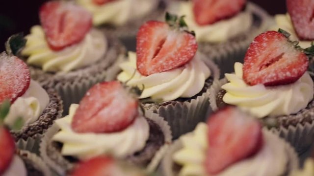 Muffins with strawberry lie on Candy Bar, close-up
