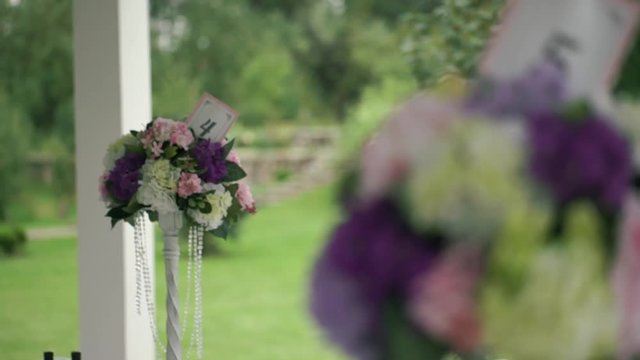 Wedding stands with numbered tables yellow, white, pink and lavender flowers.