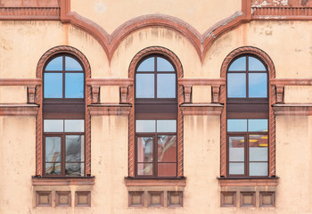 Fototapeta na wymiar Three windows in a row on facade of St. Petersburg Medical Center front view, Russia.