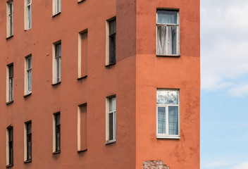 Fototapeta na wymiar Several windows in a row and corner of facade of urban apartment building front view, St. Petersburg, Russia.