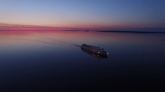 Unique aerial flight around cruise ship. Beautiful sunset. No wind. Reflection in water. 4k footage.