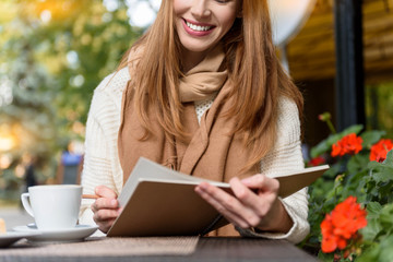 Joyful young woman studying in cafe