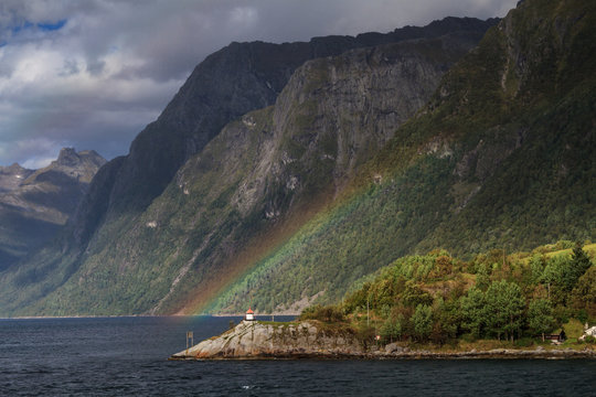 Rainbow and lighthouse at Hjorundfjord