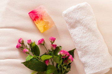 Handmade soap and roses on white leather background