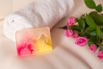 Handmade soap and roses on white leather background