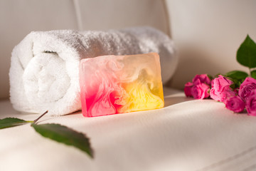 Handmade soap and roses on white leather background