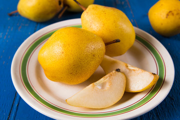 Fresh ripe organic yello pears on blue rustic wooden table, natural background, diet food.