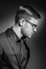 Handsome young man in a suit and fashionable glasses