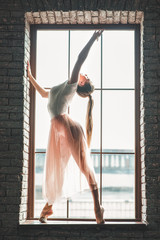 Young dancer posing at camera near window