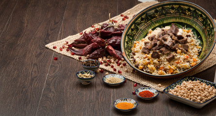 Eastern pilaf with spices and dried chilli on a wooden board