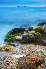 Landscape of the sea shore with a long exposure. The stones of g