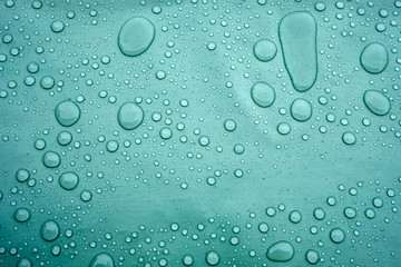 Drops of water on a dusty green color background. Shallow depth of field. Selective focus. Toned.
