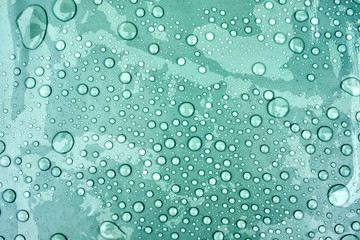 Drops of water on a dusty green color background. Shallow depth of field. Selective focus. Toned.