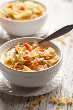 Homemade Turkey Noodle Soup on weathered white wood