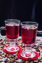 Fruit tea in a two glass cups on a grey stone background