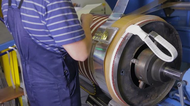 Plant electrician worker installing parts, assembling electical engine, transformer. HD