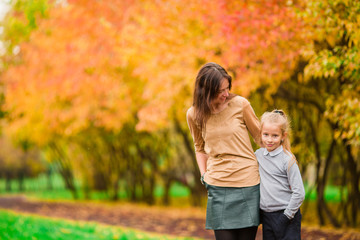 Family in fall. Mother and kid enjoy warm autumn