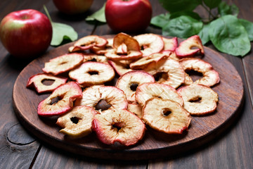 Apples chips on wooden board