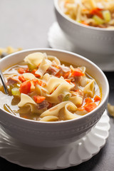 Homemade Turkey Noodle Soup with piping hot rolls macro shot