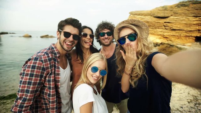 Funny friends in sunglasses taking selfies.