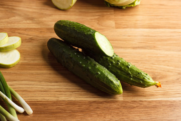 Green cucumbers on the wooden background