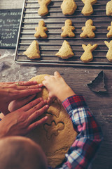 Child cutting gingerbread of metal molds