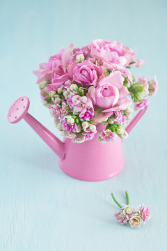 Pink spring bouquet of fresh flowers on a blue background .