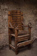 Medieval spiked torture armchair in dark room