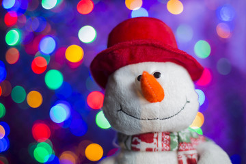Snowman in red hat on lights background