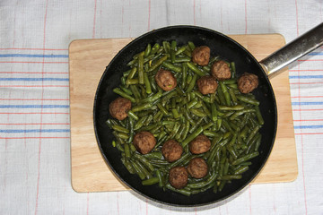 Swedish meatballs with green beans in a skillet