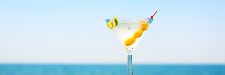 Glass of martini bianco at the wooden pier. Concept of summer va