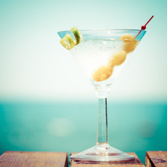 Glass of martini bianco at the wooden pier. Concept of summer va