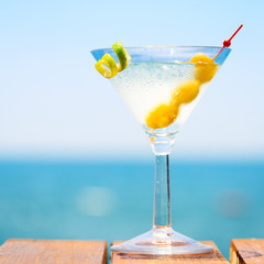 Glass of martini bianco at the wooden pier. Concept of summer va
