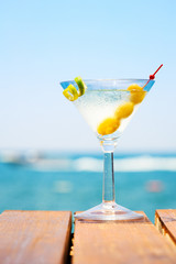 Glass of martini bianco at the wooden pier. Concept of summer va