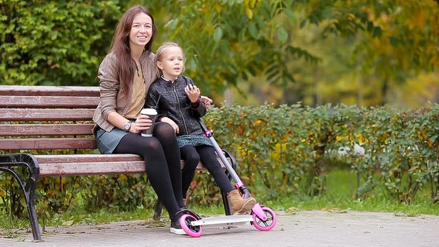 Family vacation in fall. Adorable little girl and mom enjoy fall day in autumn park outdoors