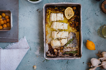Baked white fillet fish in an aluminium baking tray. Top view